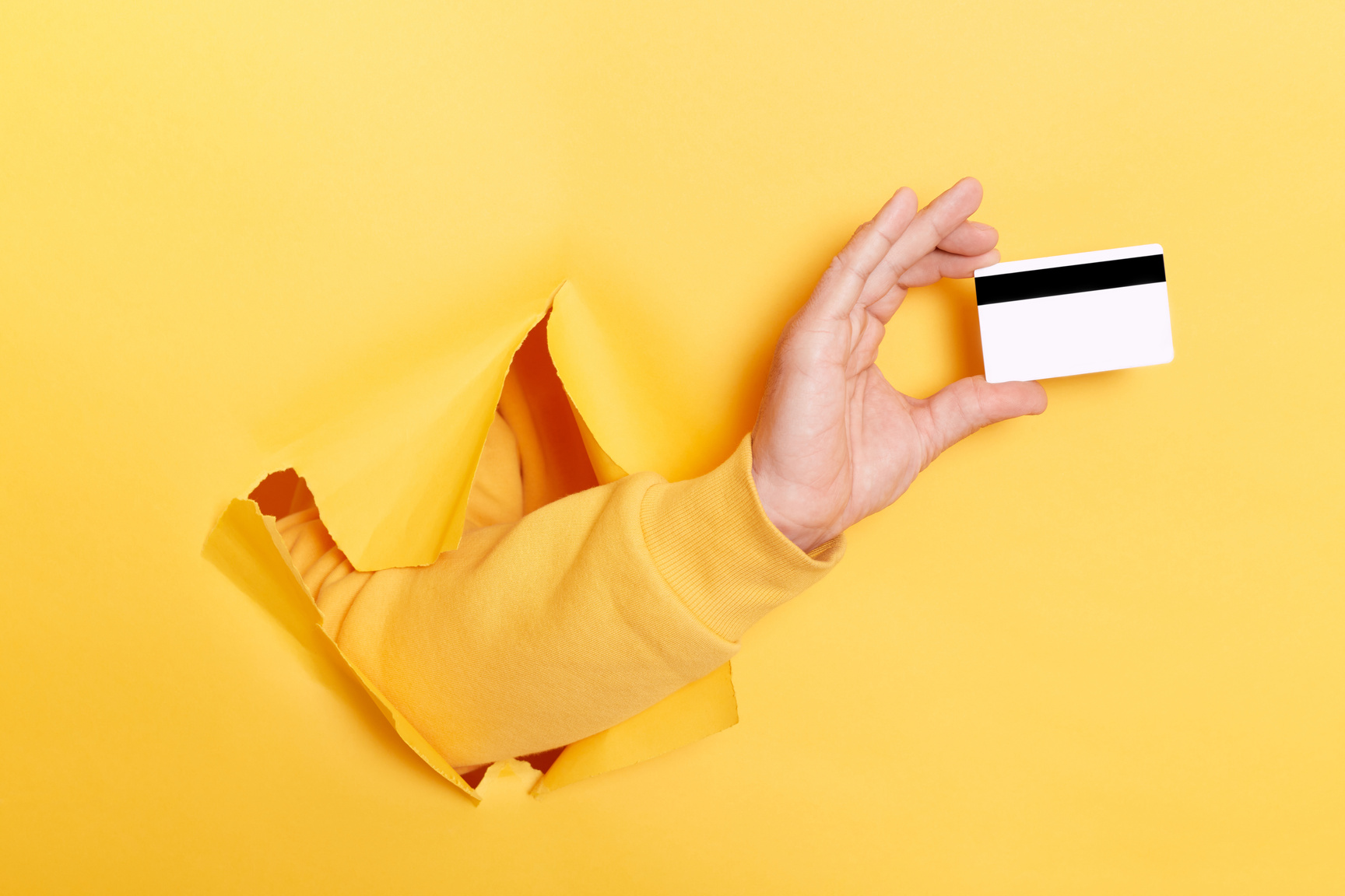 Cropped View of Man Holding Credit Card Isolated over Yellow Background with Hole, Banking, Payment, Offering Bank or Shopping Discounts.
